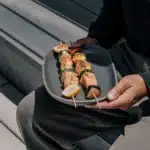 Gegrillte Fischspieße mit Lachs, Kabeljau, Garnelen und Gemüse auf einem Teller mit Zitronenspalten