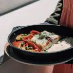 Seelachs mit Paprika und Erbsen in cremiger Sauce, serviert mit Langkornreis
